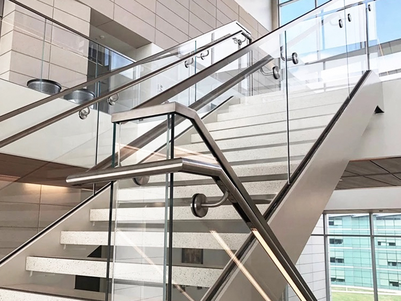 A staircase with a stainless steel handrail.