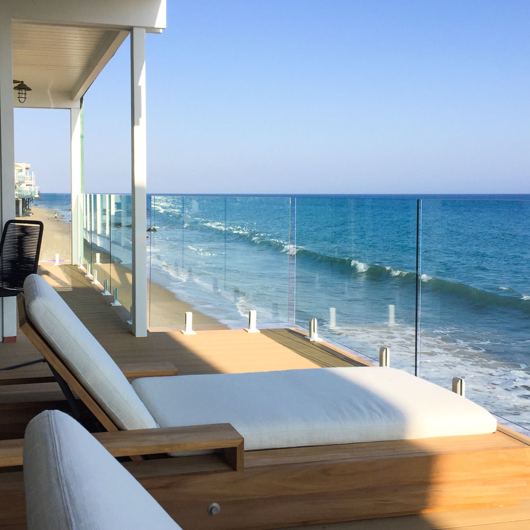 Glass railing with stainless steel glass clips for beachfront balconies.