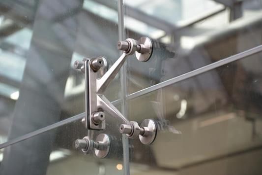 A stainless steel spider clip on the glass.