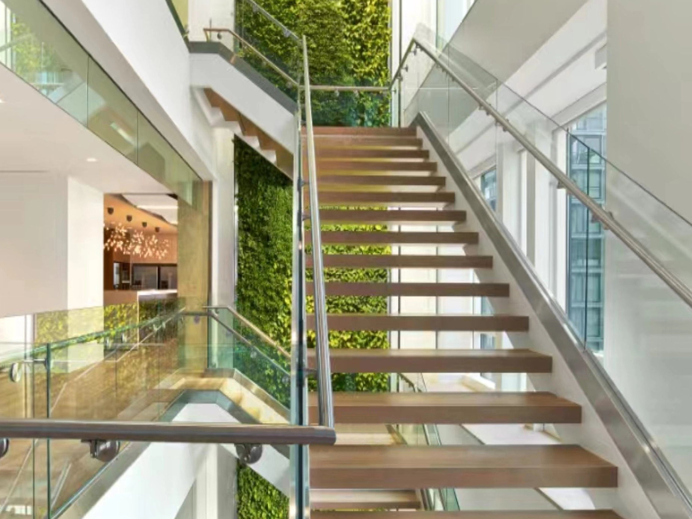 Interior staircase, stainless steel handrail, background green wall